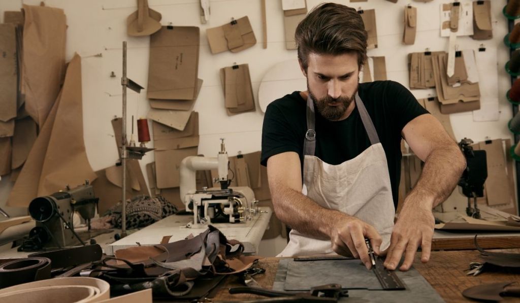 man cutting out leather